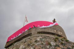 Elzabeth Castle flags. Blowing Against the Wind – art exhibition A new art installation by UK artist Katrin Mountain involving giant flags/ banners at Elizabeth Castle, which is being officially launched on 5pm-7pm on Friday, 26 July. Scott Vautier of V & V Stonemasons secures the highest banner to the German observation tower at the top of the castle Picture: JON GUEGAN