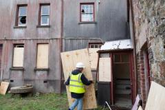 John Ovenden, Clerk of Works for the National Trust, boarding up windows at La Ronde Porte, the 18th century farmhouse gifted to the Trust in 2022 which has been vandalised Picture: JON GUEGAN