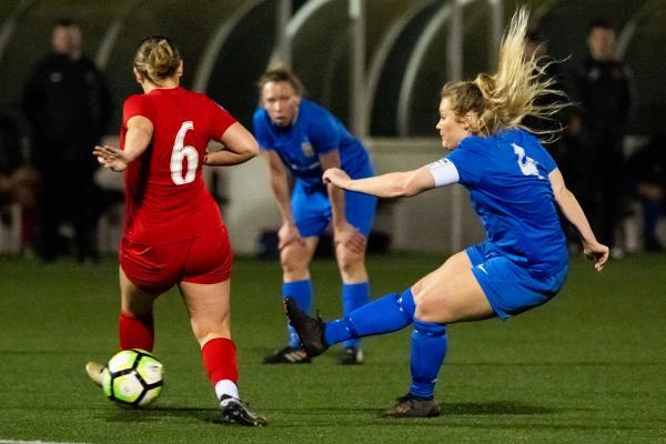 Football at Springfield. Jersey FA Women (blue) vs Army FA Women (red). Libby Barnett shoots at goal through the legs of Emily Ellis                          Picture: ROB CURRIE