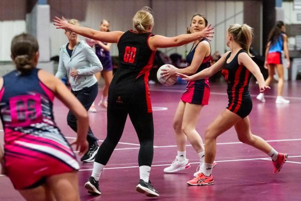 Netball at Les Ormes. St Lawrence A (purple) V St Clement A (black). Heather rabet with bal                              Picture: ROB CURRIE