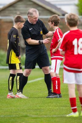 Football at FB Fields. Jersey Primary schools football festival. Jersey A (red) V Gloucester A (black). L>R Charlie Martin, Mark Le Cornu , referee talks to Mason Woodley who deliberately tripped a player when play had stopped prior to a throw in                            Picture: ROB CURRIE