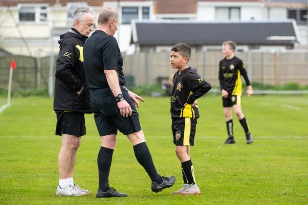 Football at FB Fields. Jersey Primary schools football festival. Jersey A (red) V Gloucester A (black). L>R  Referee Mark Le Cornu talks to La'Vai Ellis                           Picture: ROB CURRIE