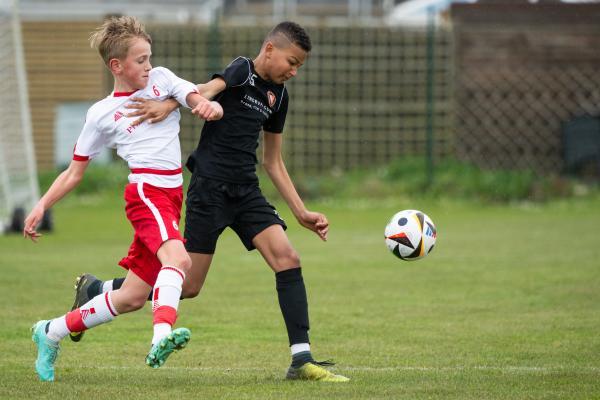 Football at FB Fields. Jersey Primary schools football festival. Jersey B (white) V Newbury A A (black). L>R Taylor Nelson and Malik Gaye                            Picture: ROB CURRIE